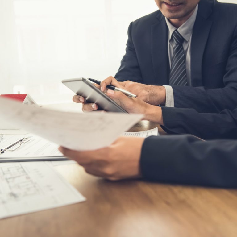 Real estate agent with client or architect team discussing work on tablet computer screen
